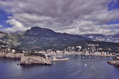 Aerial view of cityscape against cloudy sky