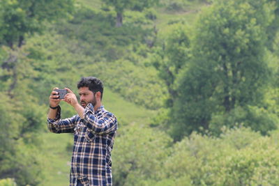 Young man photographing through camera