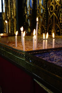 Illuminated candles against building