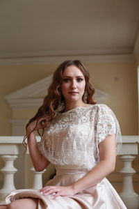 Portrait of beautiful young woman sitting indoors