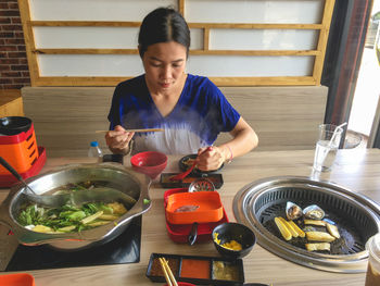 Woman holding food on table at home