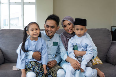 Happy friends sitting on sofa
