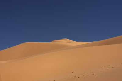 Scenic view of sahara desert against clear blue sky, libya