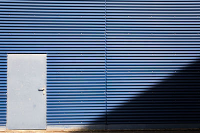 Closed blue door of garage on sunny day