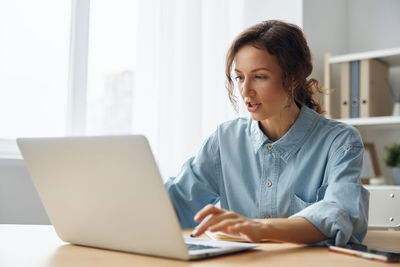 Businesswoman using laptop at home