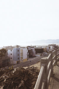 Buildings by sea against clear sky