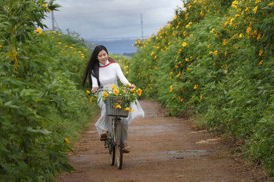 Portrait of woman with bicycle on tree