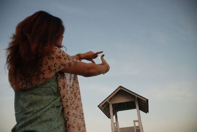 Low angle view of woman against sky