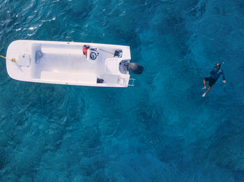 Man swimming by motorboat in sea