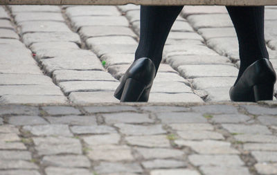 Low section of woman walking on footpath