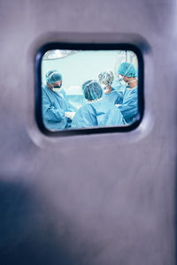 Reflection of men on side-view mirror