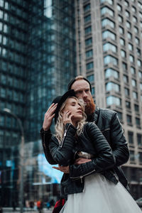 Young woman standing against building in city during winter