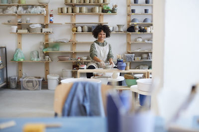 Portrait of smiling woman learning pottery in art studio