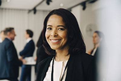 Portrait of smiling businesswoman at office seminar