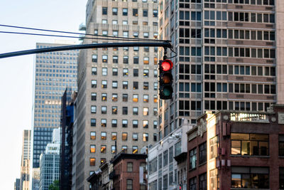 Low angle view of traffic signal against buildings