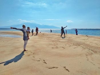 People at beach against sky