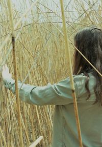 Rear view of woman holding plants