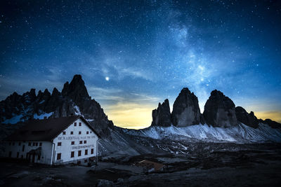 Scenic view of snowcapped mountains against sky at night