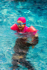 Toddler girl swimming in the pool.cute happy little girl in goggles swimming.