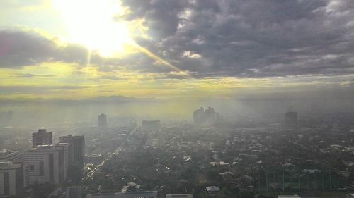 Aerial view of city against cloudy sky