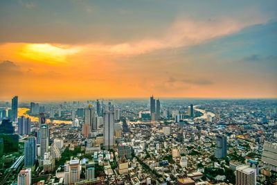 High angle view of modern buildings against sky during sunset