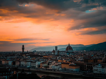 High angle view of river by buildings against sky during sunset