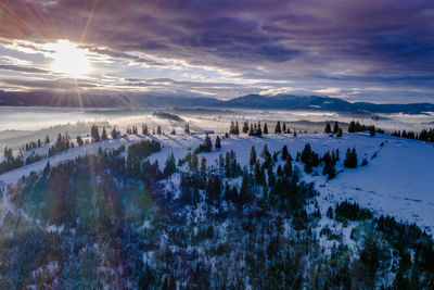 Panoramic view of snowcapped landscape against sky during sunset