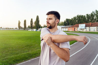 Young man looking at camera against sky