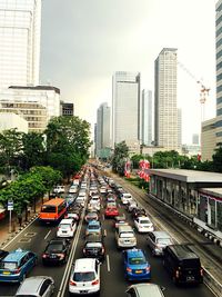 Traffic on city street by buildings against sky