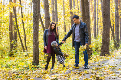 Full length of young woman standing in forest