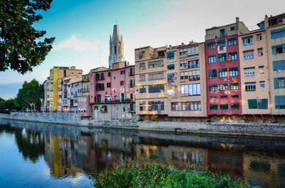 Buildings by lake against sky in city