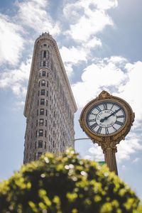 Low angle view of clock tower amidst buildings against sky