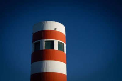 Low angle view of lighthouse against clear blue sky