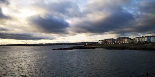 Scenic view of sea and buildings against sky