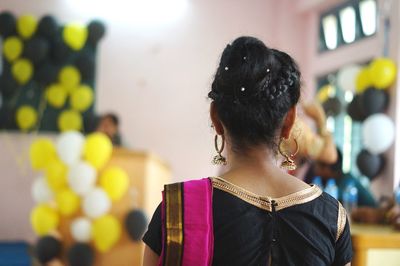 Rear view of woman standing against blurred background