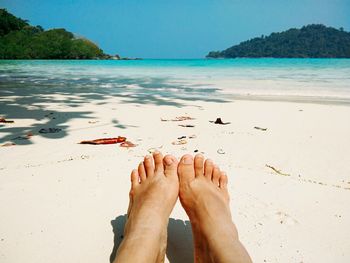 Low section of person relaxing on beach