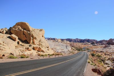 Desert road between rocks against clear sky
