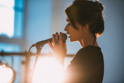 Close-up of young woman singing on stage