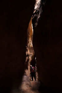 Woman explores sandstone slot canyon near escalante river, utah