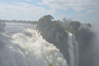 Scenic view of waterfall against sky