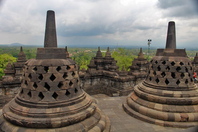Stupas of temple against cloudy sky
