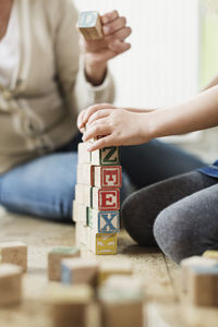 Cropped image of teacher and student stacking blocks