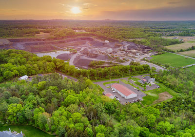 High angle view of trees and buildings against sky at sunset