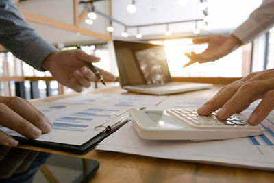 Close-up of people working on table