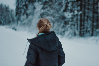 Rear view of woman standing in forest