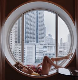 Sensuous woman relaxing at circular window