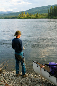 Full length of man fishing while standing by yukon river