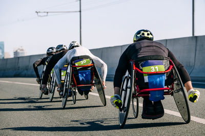 Rear view of man riding bicycle on street