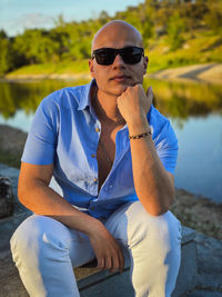 Portrait of young man wearing sunglasses sitting outdoors