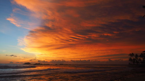 View of calm sea against cloudy sky during sunset